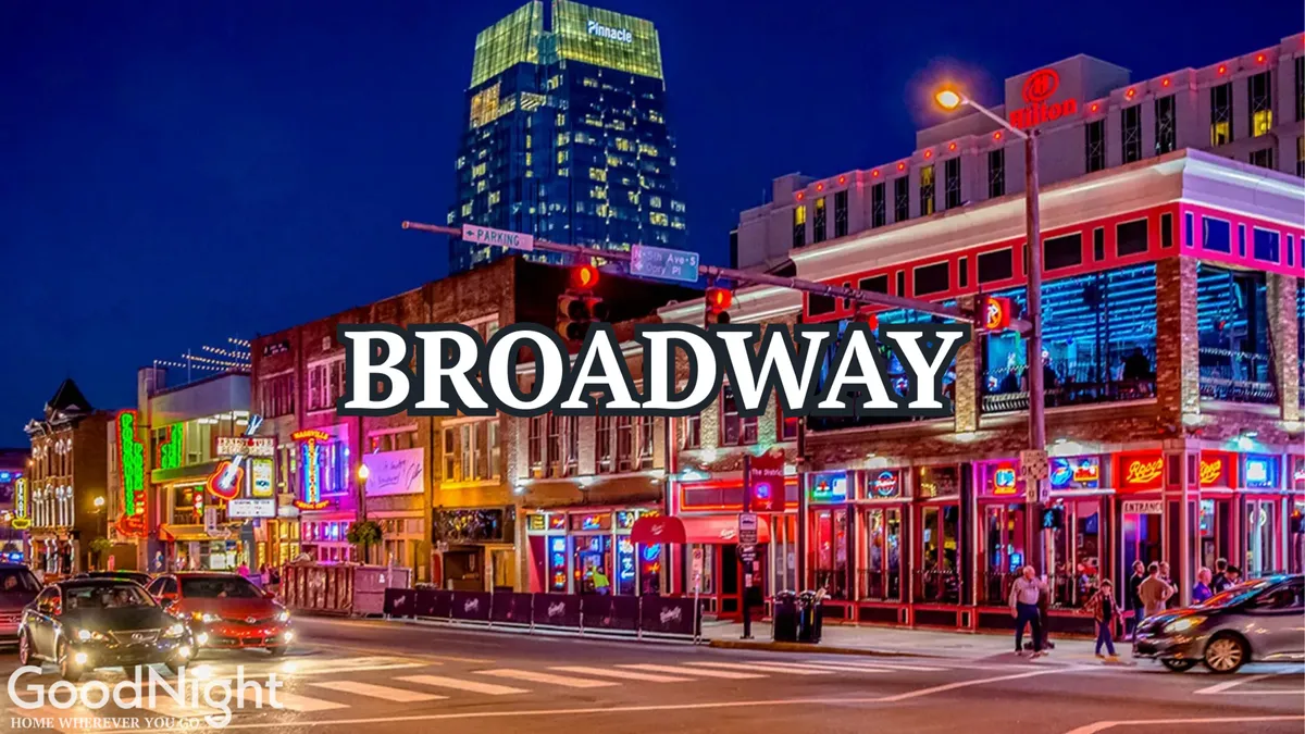 A bustling Nashville street at night features glowing neon signs, vibrant storefronts, and people enjoying the lively nightlife. The image captures the energy and excitement of Nashville’s downtown after dark.