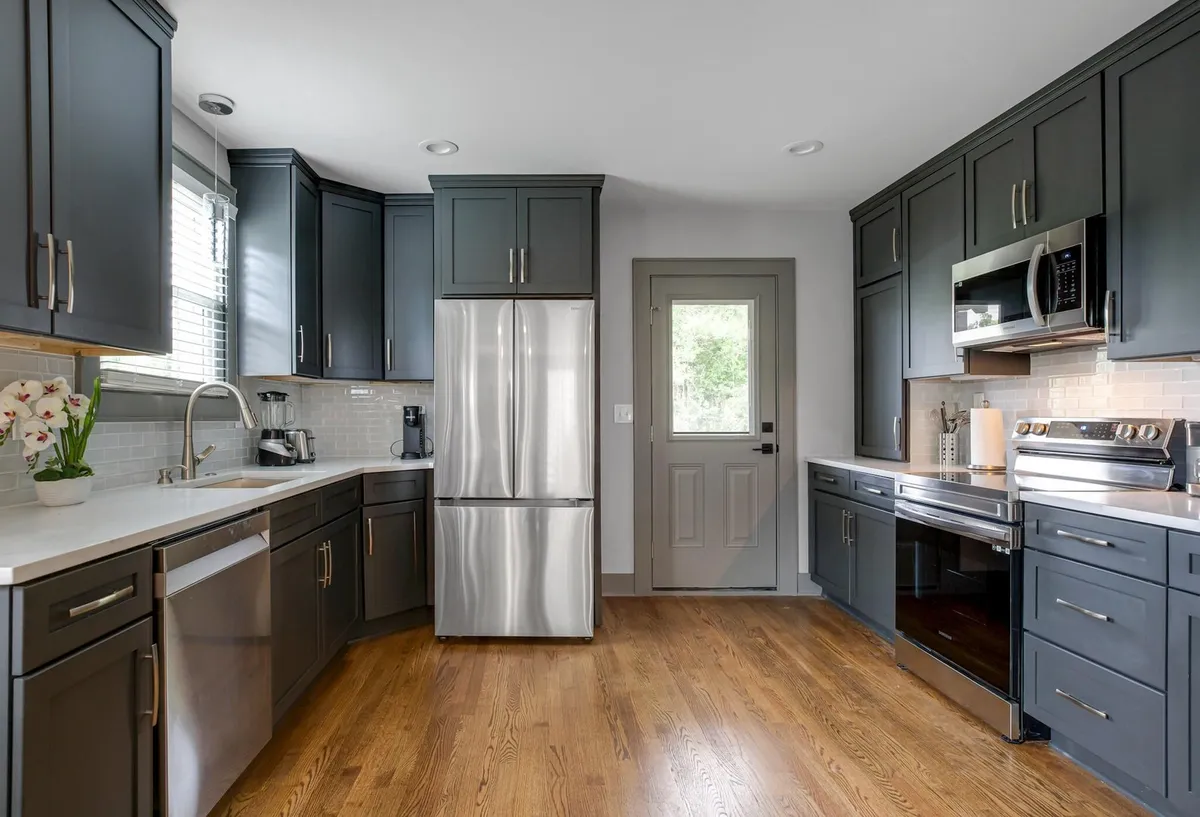A modern kitchen space featuring stainless steel appliances, dark cabinetry, clean countertops, and a central kitchen island. The layout is open and functional, perfect for cooking and entertaining. Subtle decor adds warmth without cluttering the space.