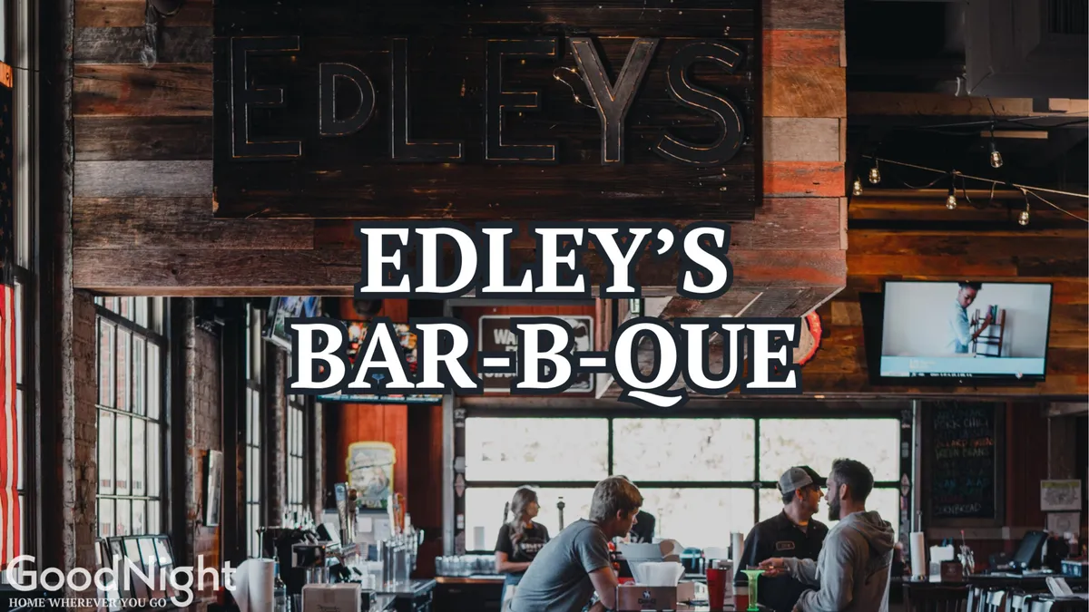 Inside Edley’s Bar-B-Que, the lively bar area is filled with patrons enjoying food and drinks under the glow of a large ‘EDLEY'S BAR-B-QUE’ sign. The mood is communal and energetic, capturing the experience of dining at a local favorite within walking distance.